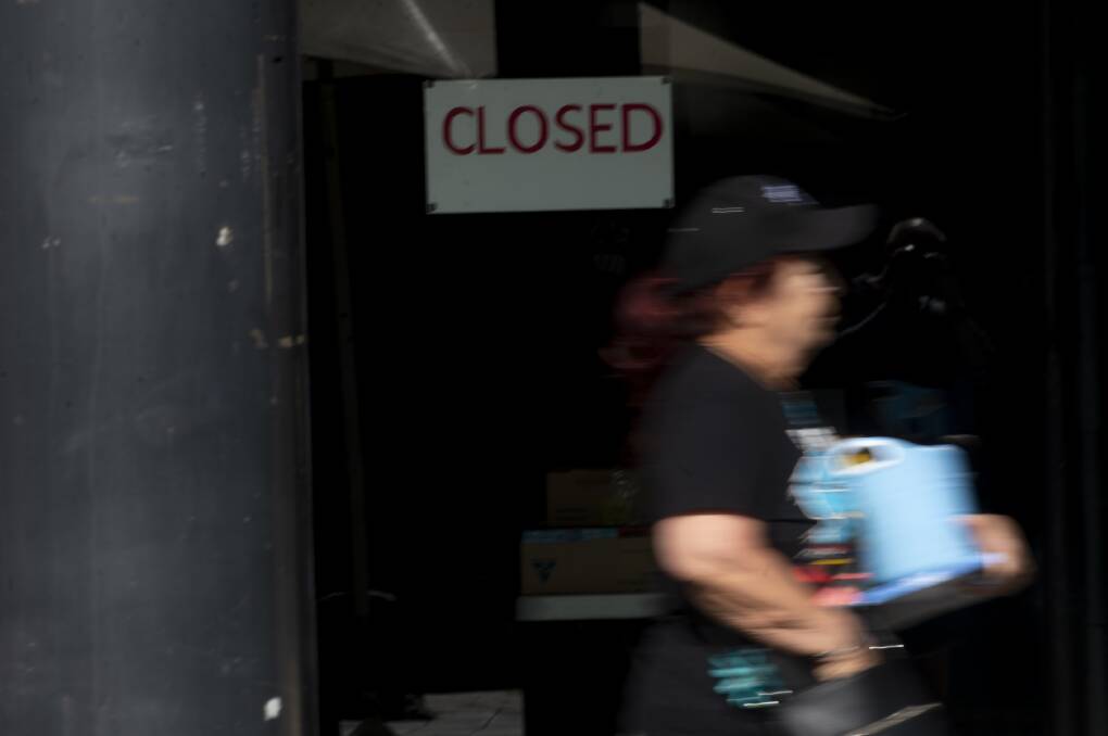 PANDEMIC'S LONG TAIL: A shopper walks past a closed shop at the height of the COVID-19 pandemic in 2020. Picture: DARREN HOWE
