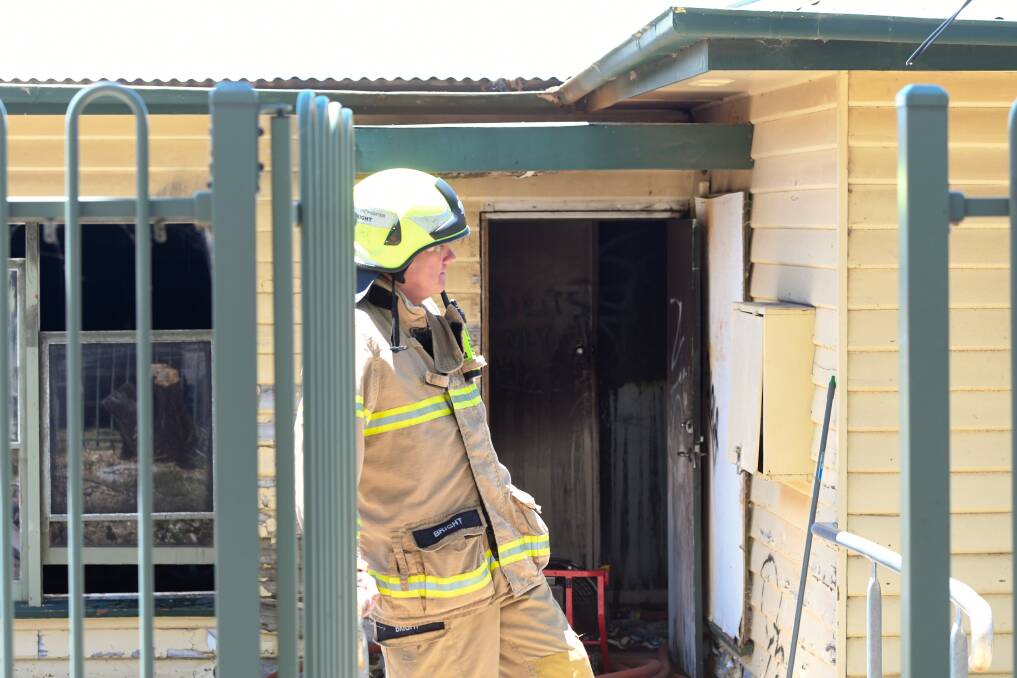 Firefighters mop up following a fire on Wednesday afternoon in Williamson Street. Picture: NONI HYETT
