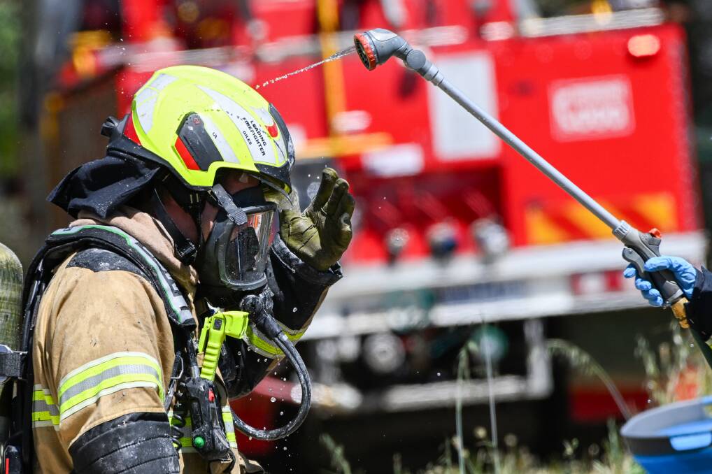 A firefighter is hosed down after battling a building fire. Picture is a file photo by Darren Howe