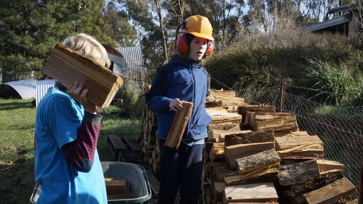 Fionn Kennedy and Jack Nielson-Bridfoot stacking firewood for the season as part of our monthly working bees. Picture: CONTRIBUTED