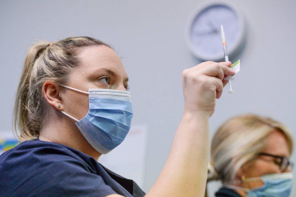 A health worker prepares a dose of COVID-19 vaccine. Picture: DARREN HOWE