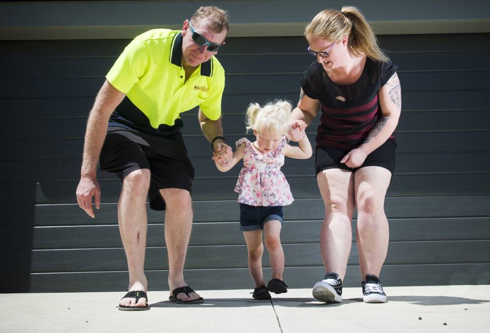 Lexie walked for the first time unassisted in 2016, with proud parents Daniel and Kerrie watching on. Picture: DARREN HOWE