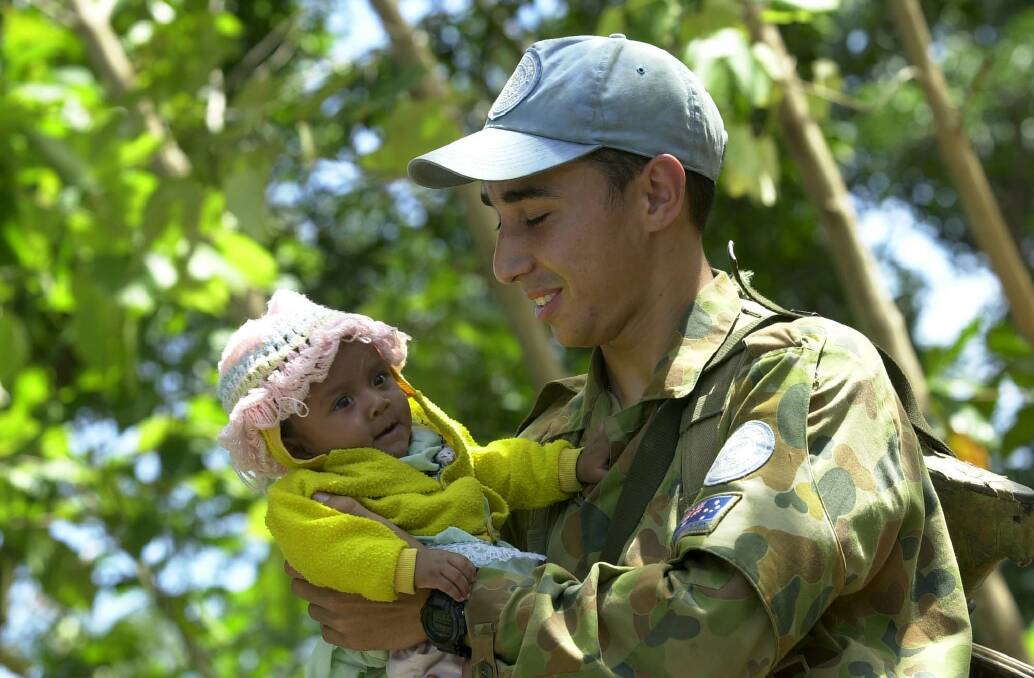 Private Carlos Antonio gets to know the local community during a patrol through the village of Memo during 2001 peacekeeping duties in Timor-Leste. Picture: Gary Ramage
