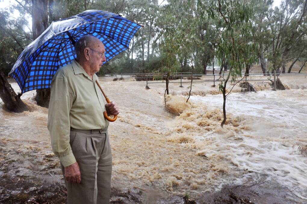 Ern Stephens watches floodwater in Browning Street, in March 2010. Picture: BRENDAN MCCARTHY