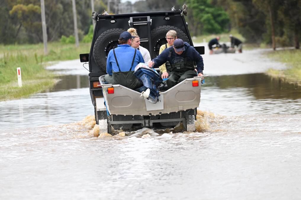 Rochester residents hitch a lift as widespread flooding continues. Picture by Darren Howe.