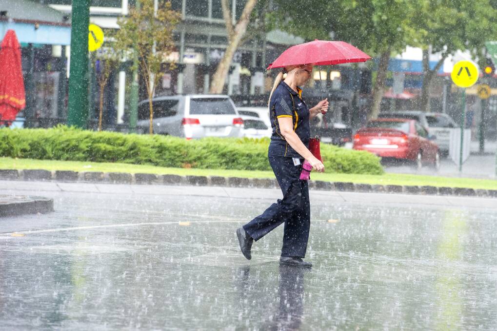 A pedestrian crosses the road in Bendigo during a rain storm last January. Picture: DARREN HOWE