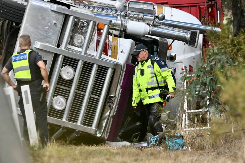 Police officers at the scene of truck rollover in Axedale. Picture by Darren Howe
