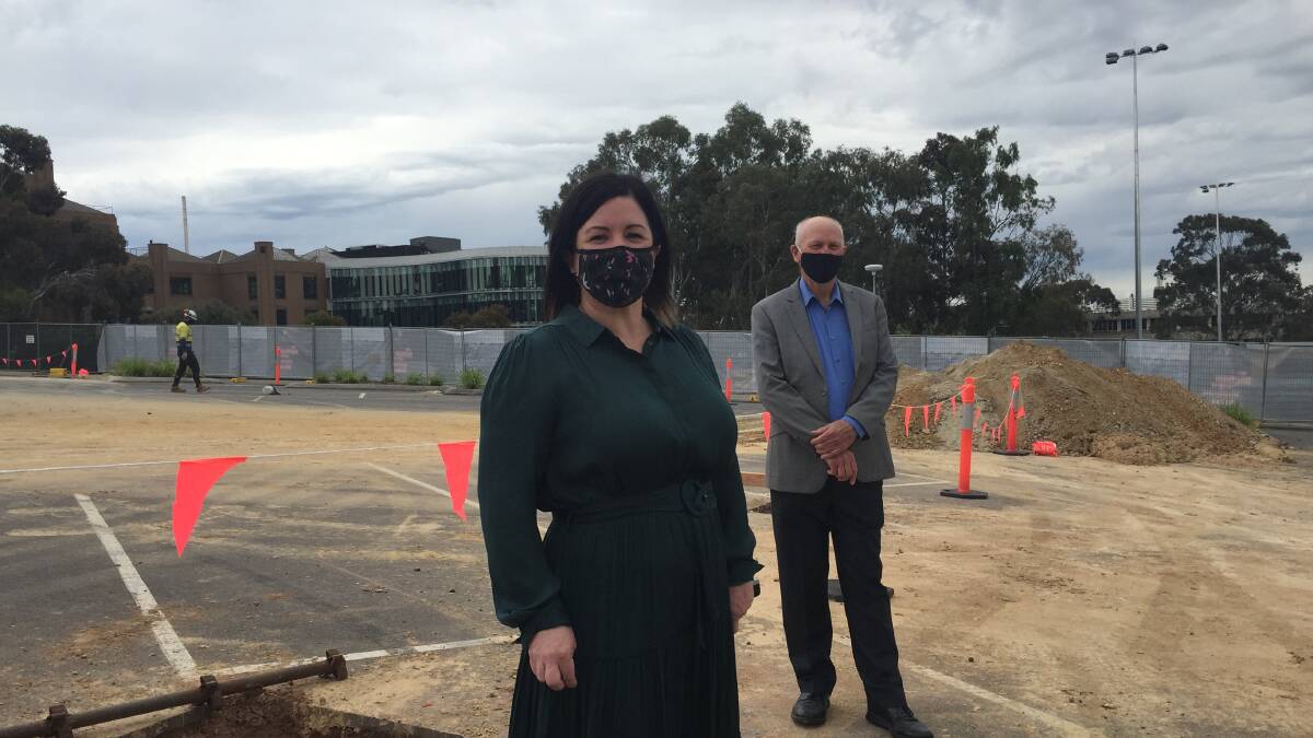 Melanie Bish and Colin Lambie stand in a car park that will soon feature car ports complete with solar panels. Picture: TOM O'CALLAGHAN