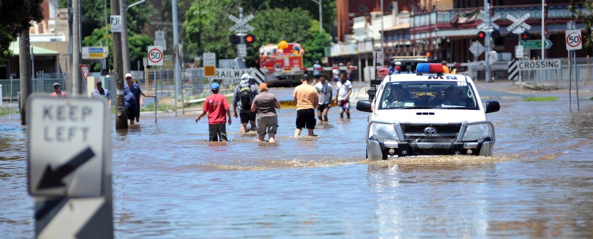 People navigate rising floodwaters during Rochester's 2011 floods. Picture by Julie Hough.