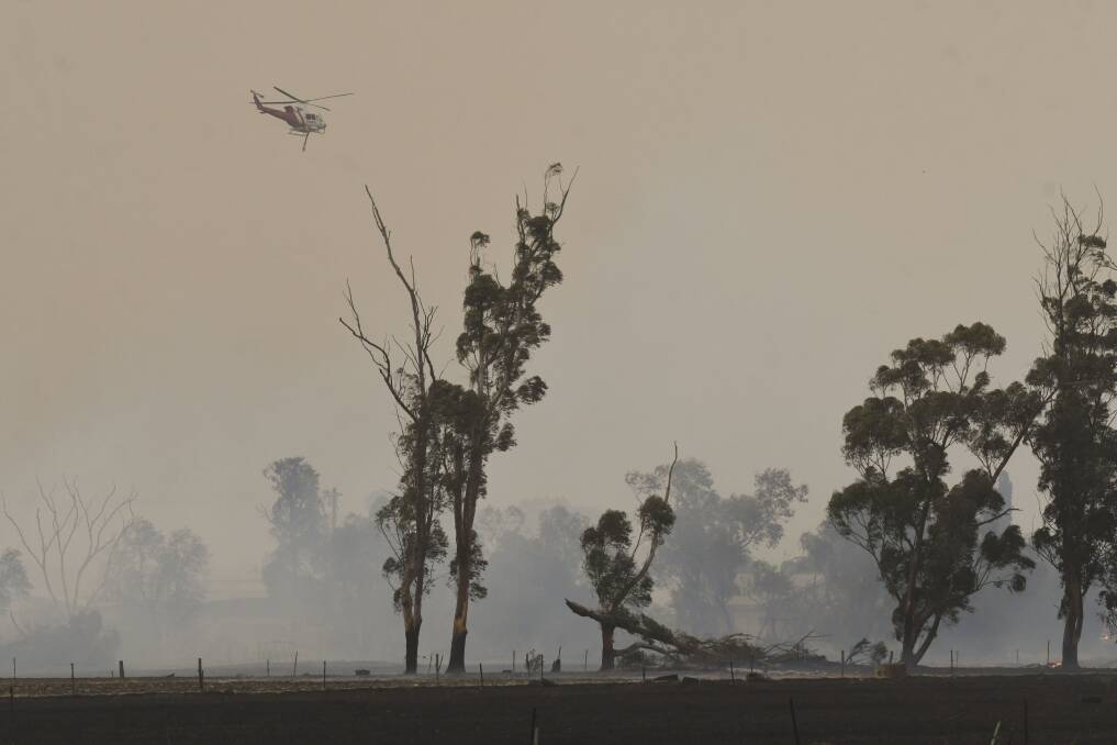 A helicopter battles a fire near Rochester on the code red day seen last November. Picture: NONI HYETT 