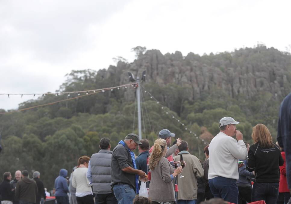 Concert goers watch a concert in East Paddock, overlooked by Hanging Rock. Picture: JODIE DONNELLAN
