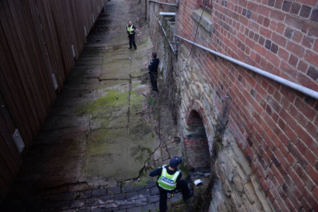 A police officer peers into a Bendigo Creek drain during the search for a prisoner who escaped custody in 2014 (not from the Bendigo Prison). Picture: JIM ALDERSDEY