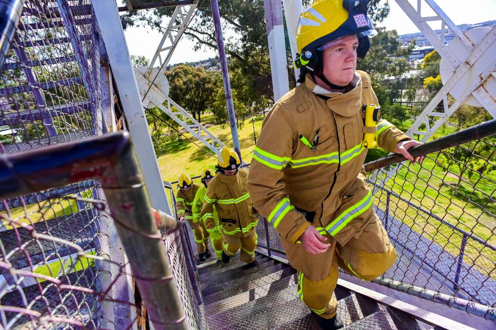 READY FOR ACTION: Kangaroo Flat Fire Brigade members race up a Bendigo poppet head as they train for a gruelling stair climb in Melbourne. Picture: BRENDAN McCARTHY