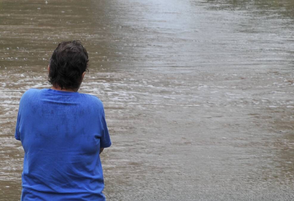 DELUGE: A Central Victorian watches a flood in 2011. Picture: PETER WEAVING