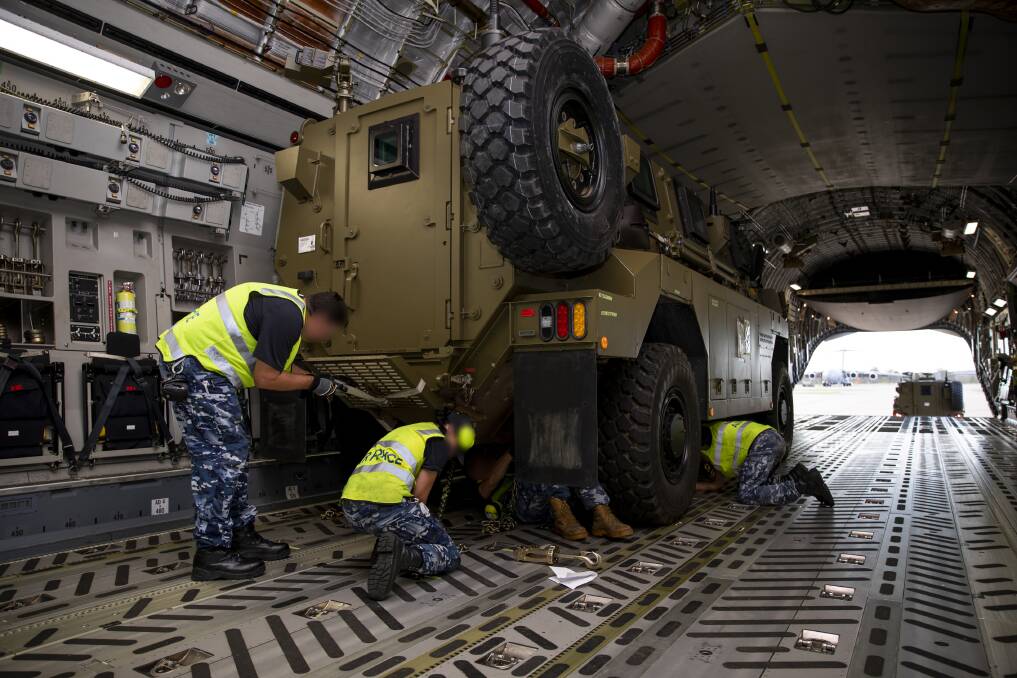 Defence force workers fitting a Bushmaster into a C-17 plane last April. Picture supplied by Defence/Emma Schwenke 