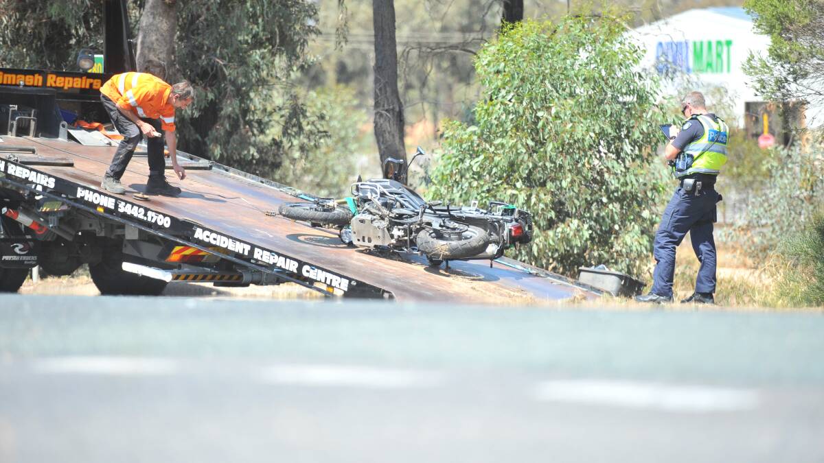 A damaged motorbike is removed from the scene of a crash. Picture: TOM O'CALLAGHAN