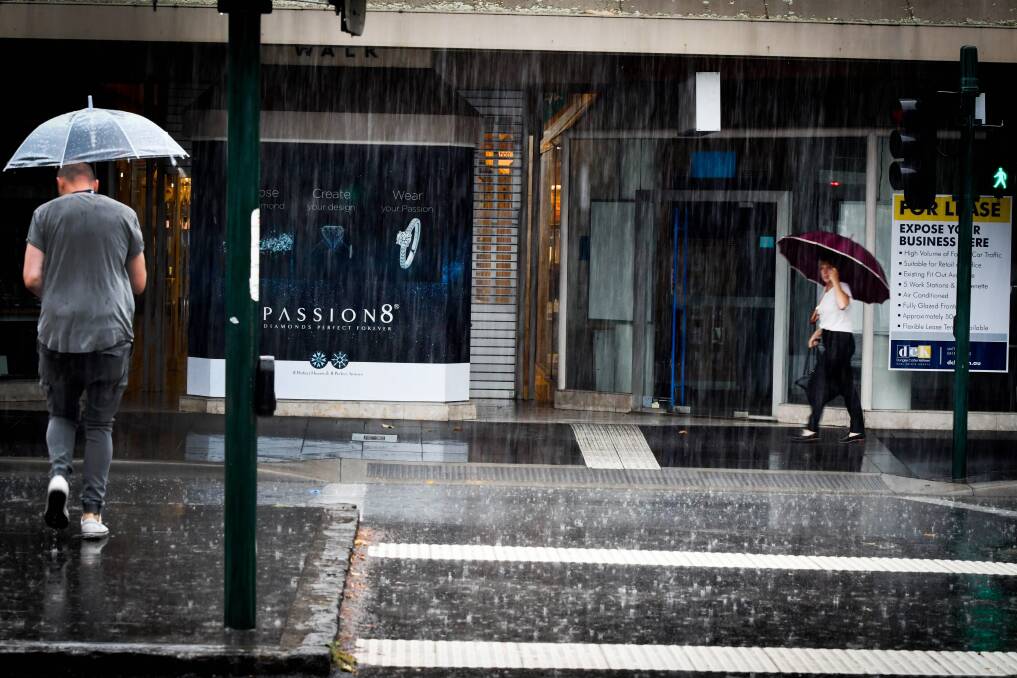 Shoppers in Bendigo's city centre negotiate heavy rain. Picture: BRENDAN McCARTHY