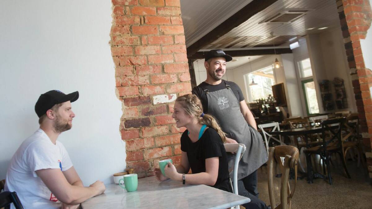 Adam Nicoletti in his cafe the Spring Gully General Store as customers Rhys Hobbs and Belle Harrington enjoy a coffee. Picture by Darren Howe