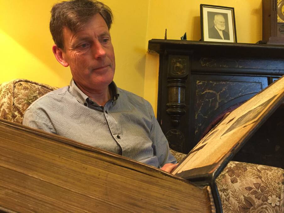 REMEMBRANCE: Stephen Kirkpatrick opens the cover of his family's Bible. The inside cover is adorned with newspaper clippings on his great-uncle Stephen, who was killed in action during WW1.