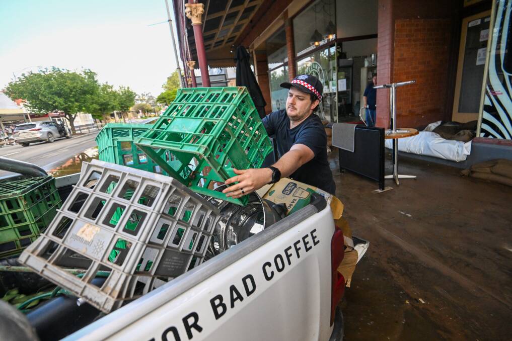 Kyle from Rochester's 7 Bean Coffee cleans up after his business was hit by the flood. Picture: DARREN HOWE