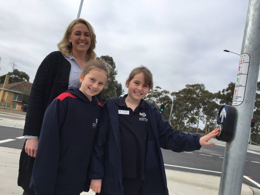 Students Eloise and Matilda join Strathfieldsaye Primary School assistant principal Julie Ladd to cross the intersection.
