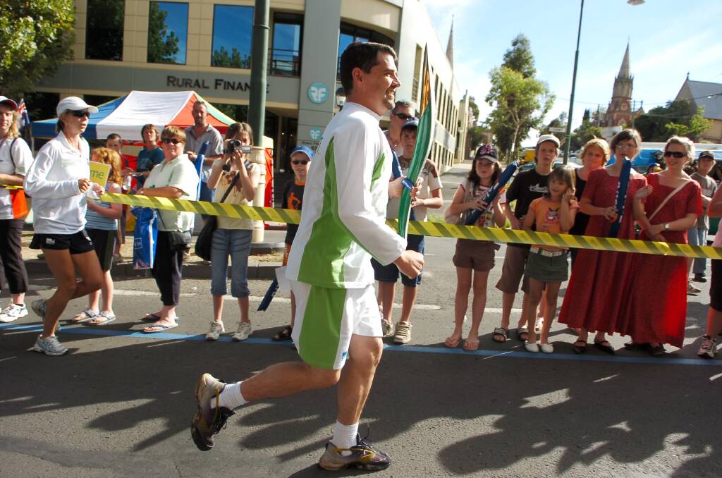 Martin Leach runs up View Street with the 2006 baton in the build up to Melbourne's Commonwealth Games. Picture by Bill Conroy