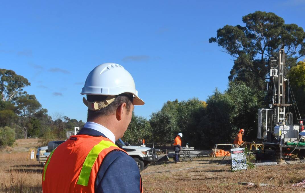 A games stakeholder watches bore holes being sunk last week at the Bendigo athletes' village site. Picture by Noni Hyett
