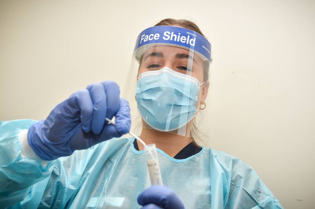 A health worker performs a COVID-19 test. Picture by Darren Howe.