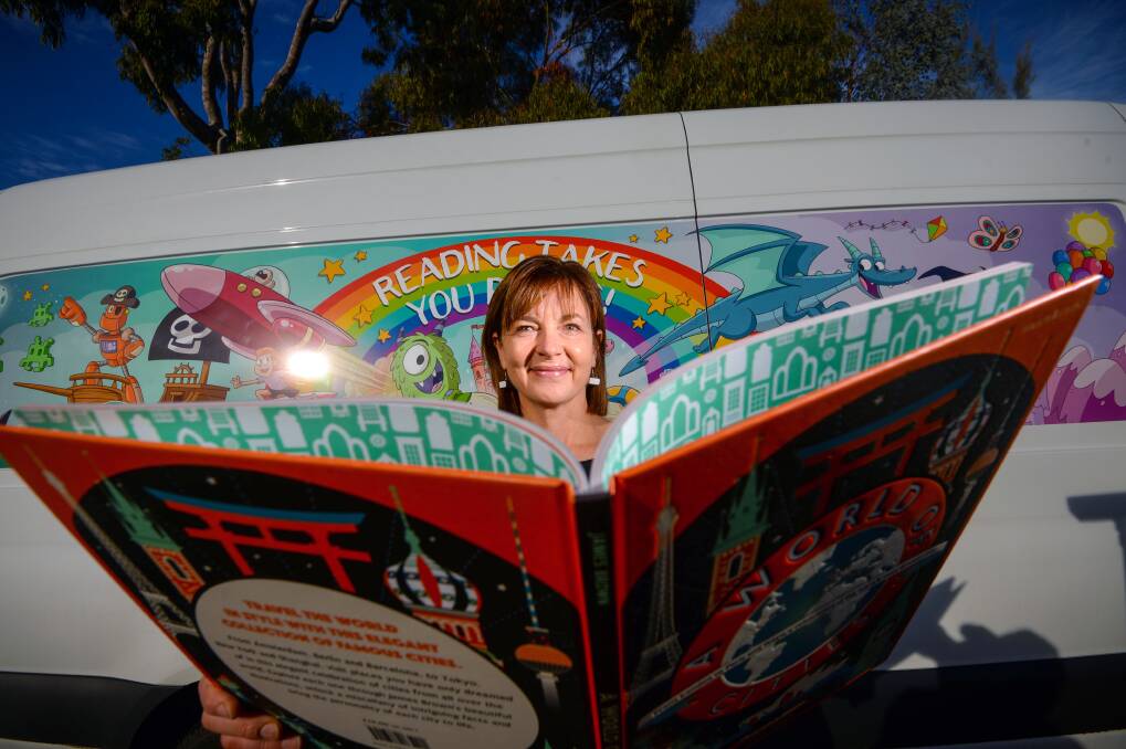READY TO READ: Mobile library teacher Sue Gentry with one of the books donated in a push inspired by the Terry Floyd Foundation's work. Picture: DARREN HOWE