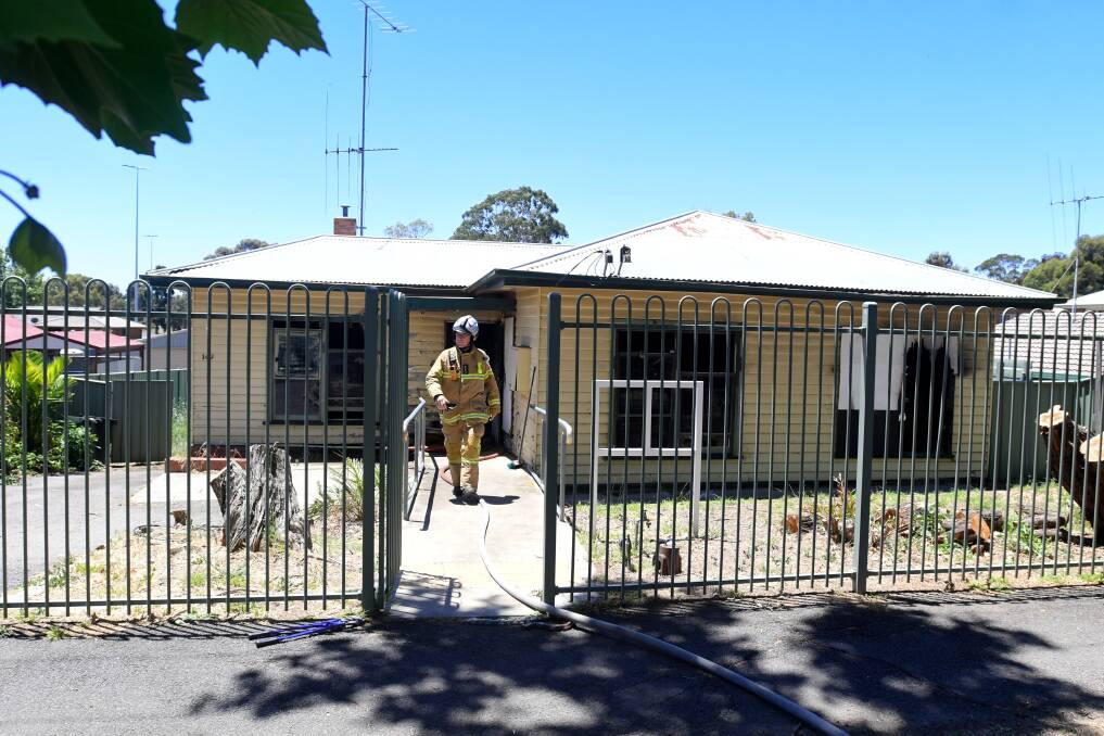 A firefighter leaves a building shortly after their team extinguished a blaze at the Williamson Street address in late 2020. Picture: NONI HYETT