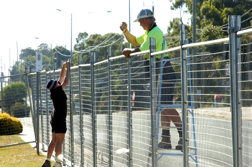People install a security fence outside Bendigo's All Seasons Resort ahead of the 2006 Commonwealth Games. Picture: PETER HYETT