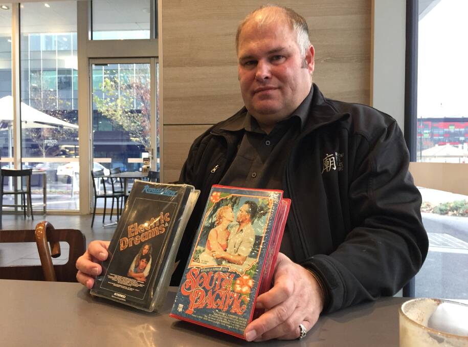 RARE PIECES: Antique collector Darren Wright with two of the tapes in his collection. Both tapes are from the early days of VHS video tapes.