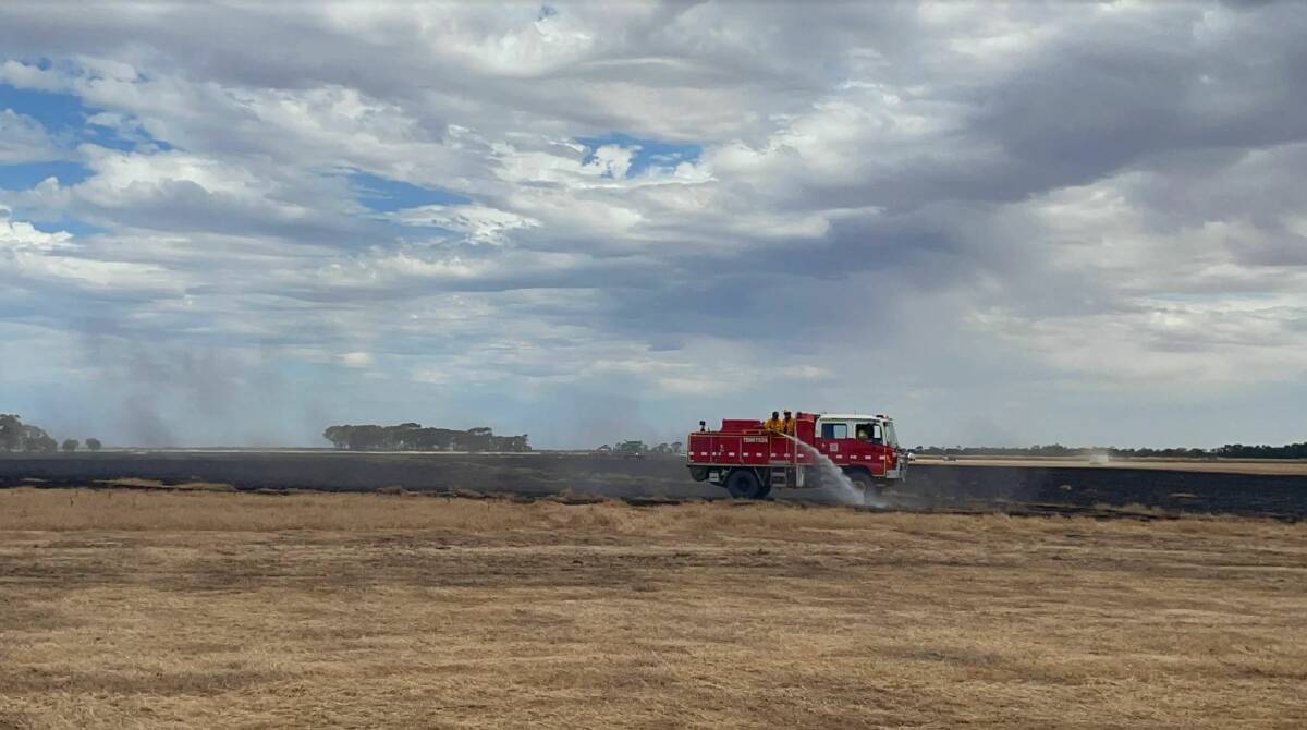 Firefighters black out a fire that burned through paddocks at Tennyson on Monday. Picture: NEVE BRISSENDEN