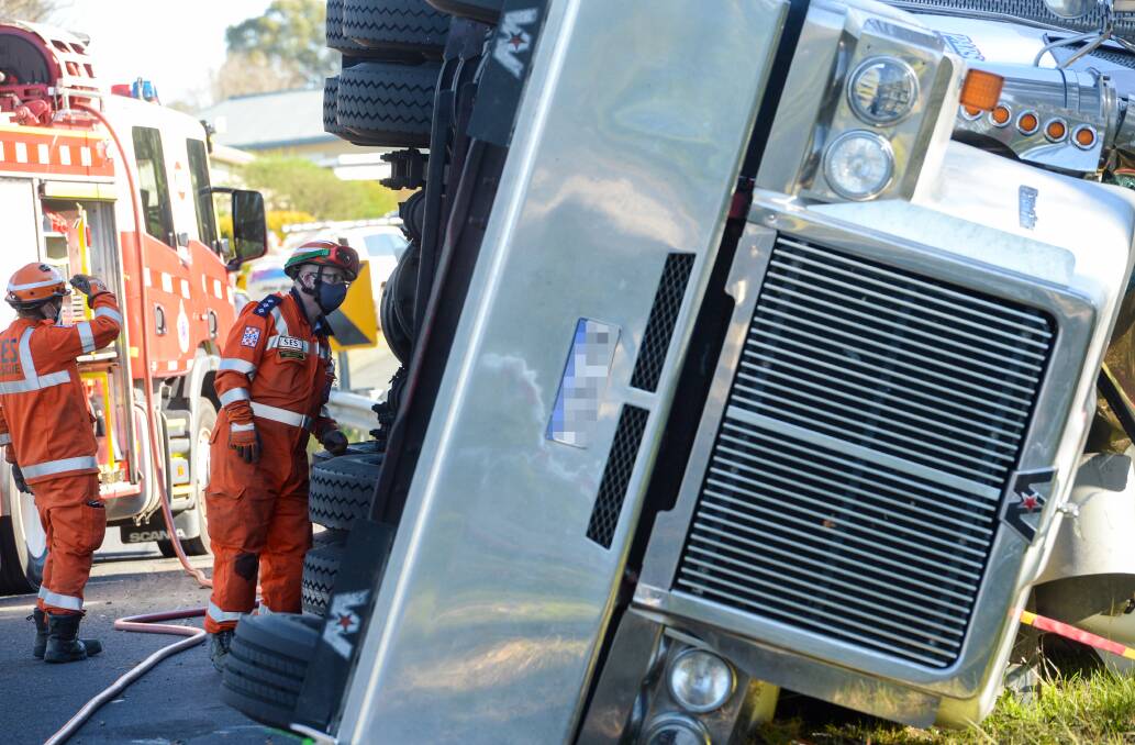 SES volunteers inspect a truck that rolled over in Creeth Street on Saturday. Picture: DARREN HOWE