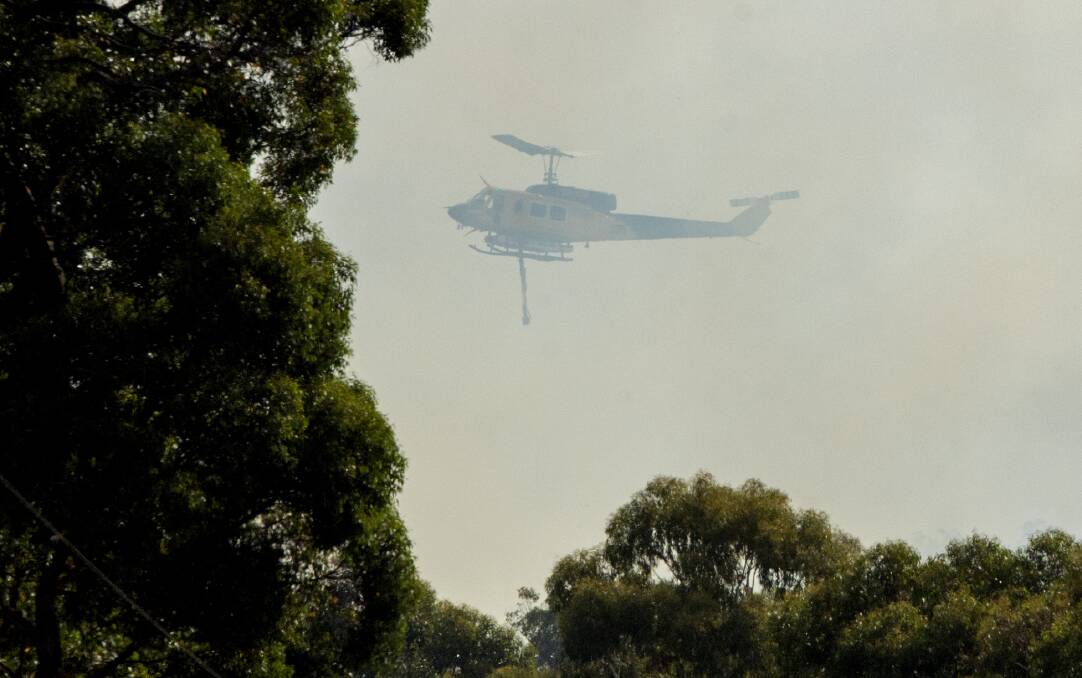 Smoke partially obscures a water bombing helicopter during a fire in Benloch in 2019. Picture: DARREN HOWE