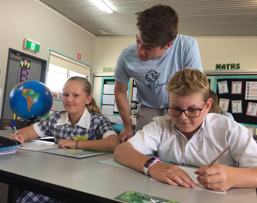 DEAR CRIS: Victory Christian College grade six students Elisha Slingo and Alex West draft letters, with facilitator Ryan Peterson providing a few handy tips. The Dear Cris program connects students with counterparts overseas.