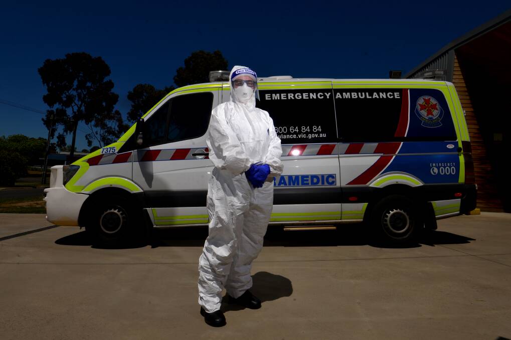 A frontline paramedic in Bendigo in full PPE kit. Ambulance Victoria is introducing more services to help ease pressure on those on the front line. Picture: DARREN HOWE