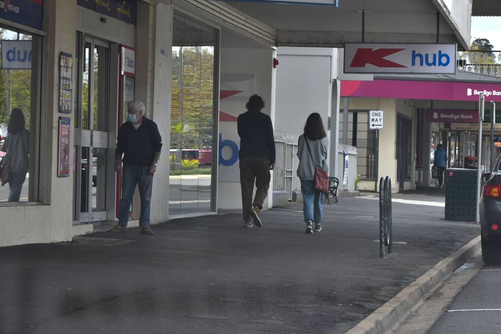 People walk past Castlemaine's K Hub after it was declared a tier two exposure site on Saturday. Picture: NONI HYETT