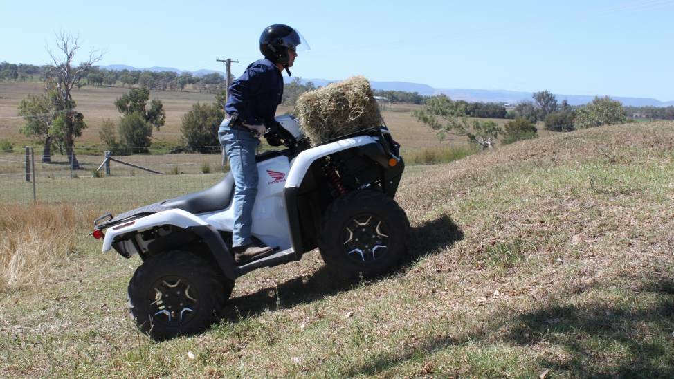 An example of a dangerous practice, with a farmer carrying a load on an ATV up a hill.