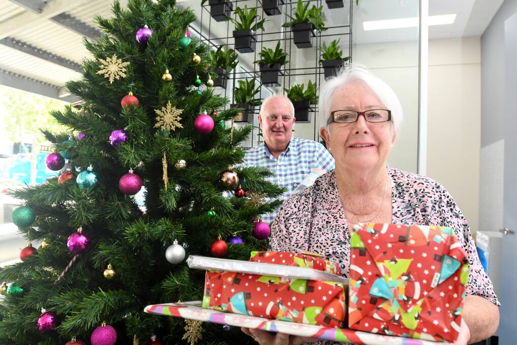SPREAD THE JOY: Tony and Karen Doolan collect gifts for Vinnies from under the Bendigo Advertiser Christmas tree. Picture: NONI HYETT