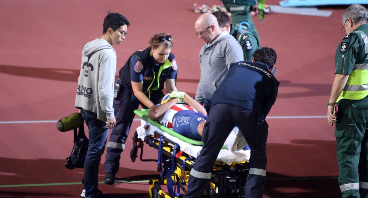 Hurt: paramedics help the injured after the crash. Picture: Glenn Daniels
