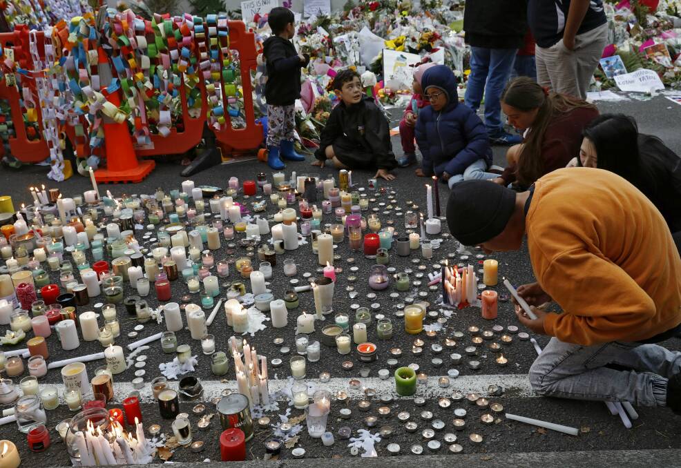 Students light candles as they gather for a vigil to commemorate victims of Friday's shooting, outside the Al Noor mosque in Christchurch, New Zealand. Picture: Vincent Yu/ AP
