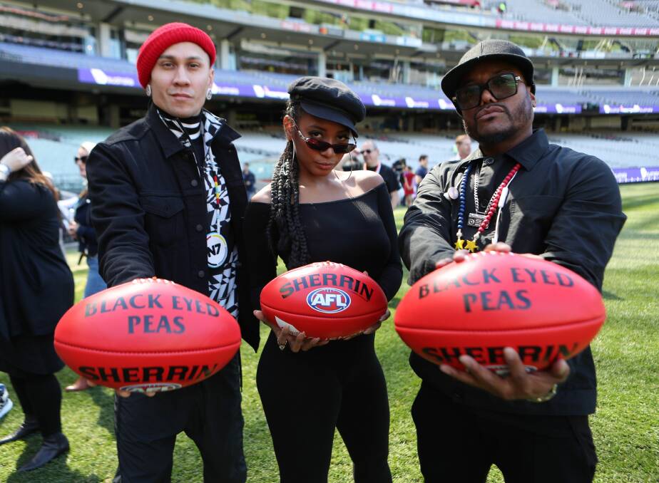 Music masters: Black Eyed Peas members Taboo (left) and apl.de.ap, and singer Jessica Reynoso get ready to perform at the AFL grand final. Picture: AAP Image/David Crosling