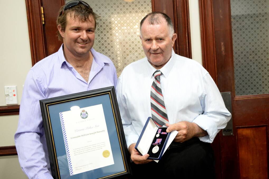 ACKNOWLEDGED: Bill Harnetty, right, and son Ben with Constable Harnetty's medal.