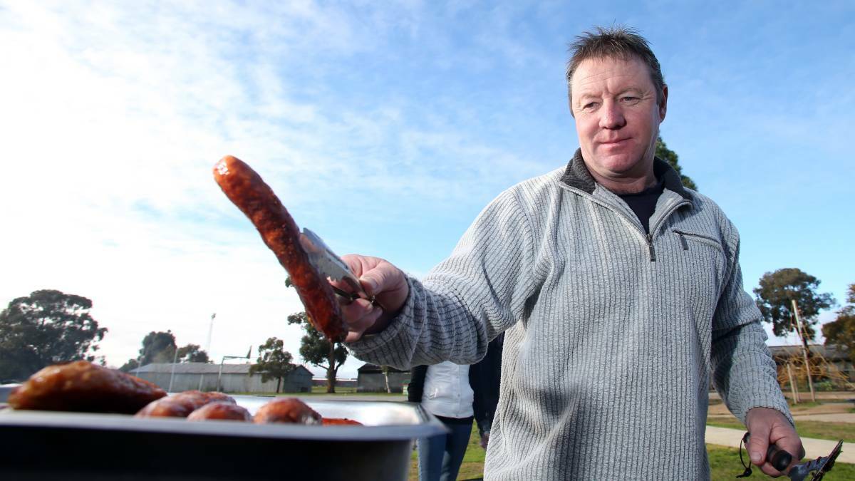 Shane Hommelhoff cooks up some snags at Lightning Reef Primary School. Picture: GLENN DANIELS