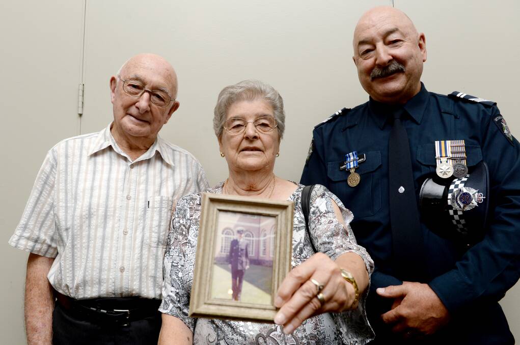 RETIRING: Leading Senior Constable Len Igoe with his proud parents - dad Charles and mum Ivy, who holds a photo of her son when he graduated from the police academy as a 19-year-old in 1975.