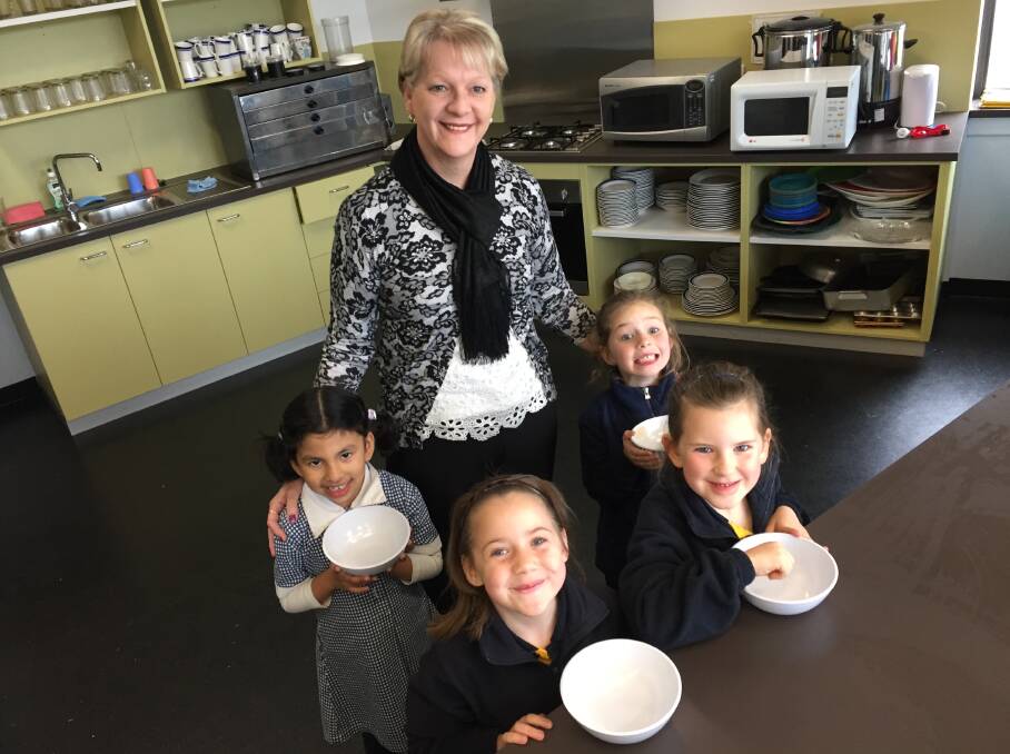 ANOTHER HELPING: Golden Square Primary School students Nusaiba, Matilda, Lily and Sofia and Bendigo West MP Maree Edwards get ready to fill their bowls for a nourishing breakfast.