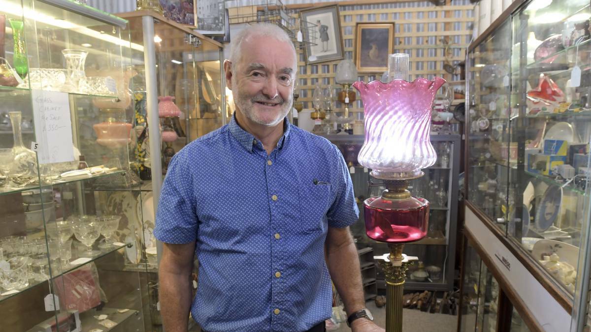 VINTAGE GOODS: Ken Smith with an 1880s Banquet Lamp. Picture: NONI HYETT. 