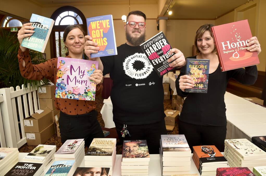 PAGE TURNERS: Bendigo Writers Festival volunteers Jesse Munzel, David Plathe and Shelley Job set up the festival's book store ahead of the first day. Picture: NONI HYETT