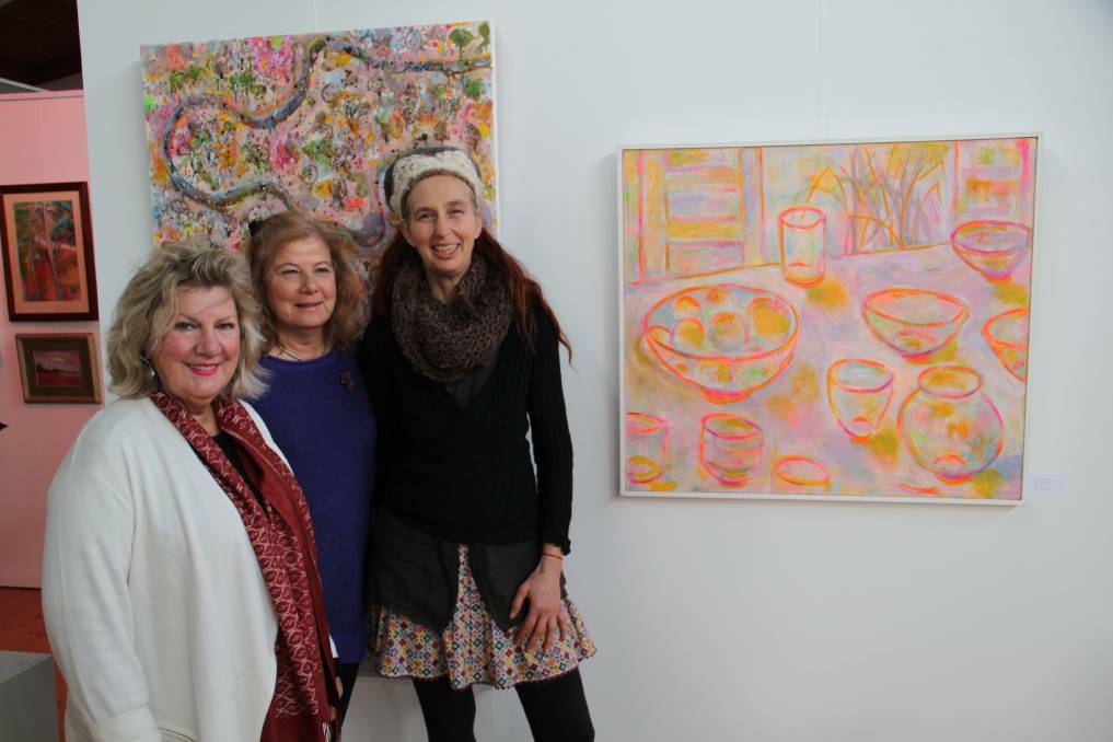 SUCCESS: Maldon artist Lorraine Taylor in front of her artwork, with Jenny Merkus from Maldon and Rosie Laszlo from Hepburn at the Market Art Winter Exhibition. Picture: SUPPLIED